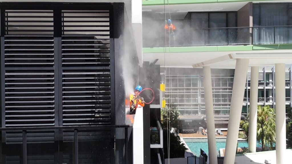 Building washdown by rope access at 9 Edmondstone St, South Brisbane