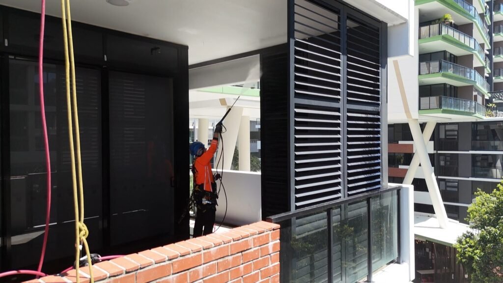 Rope access pressure cleaning on balconies at 9 Edmondstone St, South Brisbane